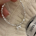 Silver bracelet with crushed silver beads, irregular pearl, and bow charm on cream sweater - Bowknot Pearl Style-SL0848