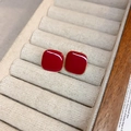 Nahaufnahme von roten quadratischen Emaille-Ohrsteckern mit Goldrahmen auf Samttablett - Rot (S925 Sterling Silber Stift)
