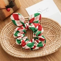 Detail of red and green plaid fabric hair scrunchie with a bow on a woven tray - Rabbit Ears Style / Christmas Plaid