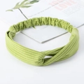 Light green twisted knot knitted headband for yoga and sports on a minimalist background - Knitted Grass Green