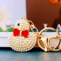 Cute golden duck keychain with white pearls and a small red bow tie for bags - White Pearl Duck