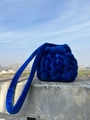 Handgewebte blaue Mini-Umhängetasche aus Samt mit Schultergurt vor städtischer Kulisse - Königsblau