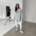 Oversized grey crewneck sweatshirt with dark green legacy print in casual studio setting - S / Gray