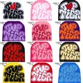 Various colorful knit beanies featuring Top Tier graffiti text and heart designs - Capybara 204