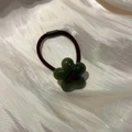 Dunkelbraunes elastisches Haargummi mit einem grünen, lichtdurchlässigen Blütenakzent - Grüne Blume Braunes Haargummi