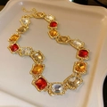 Close-up of vintage gold necklace with red and yellow rhinestones on a beige tray - 63# Necklace-Multicolor-Square