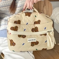 Detail of hand-held beige quilted makeup bag with brown bear patterns and top handle - Makeup Bag / Brown Bear