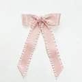 Nahaufnahme der langen rosa Satin-Schleifen-Haarklammer mit Rüschen und Bändern - Rosa