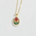 Dettaglio del ciondolo a fiore in oro vintage con pietre di zircone e smalto bianco - Stile Floreale Ovale / Bianco Rosso