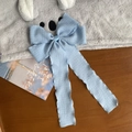 Detalle de horquilla con lazo azul claro de cintas plisadas largas y tejido suave con estilo - Azul