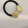 Elastic hair tie with a gold-tone hammered metal bow on an off-white leather surface - Pattern Bowknot Gold