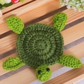 Handmade green crochet turtle coaster coaster for mugs on a rustic wooden table background - Mint Green
