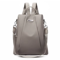 Close-up of beige nylon travel backpack with PU leather straps and metal hardware detail - Khaki