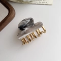 Elegant acetate and gold metal heart hair claw clip on a minimalist wooden tray - Grey Marble Pattern