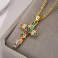 Primer plano de collar con colgante de cruz dorada y circonitas de colores en estuche de joyas - Cruz de Piedras Preciosas de Colores (23061)