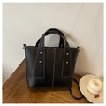 Detail of black tote bag featuring contrast white stitching and gold rivet accents - Black