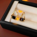 Makroaufnahme goldener geometrischer Ohrringe mit quadratischem schwarzem Edelstein - Ohrring-Gold-Schwarz (Echtgold Vergoldet)