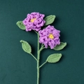 Detailed top view of handmade crochet purple rose flowers with green leaves on green texture - Gardenia Branch - Purple