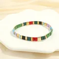 Detail of colorful enamel Tila bead bracelet with golden spacers on a white tray - BR1670-H/Rainbow Multi-color Mix