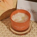 Orange ceramic scented candle with crystal stones on a woven mat for home decor - Sweet Lemon