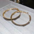 Primer plano de pendientes de aro dorados con circonitas negras de corte baguette - Dorado - Zirconia Negra