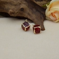 Macro de pendentifs cubes en résine rouge foncé avec bordures dorées sur fond bois - Rouge Translucide