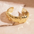 Detailed view of gold open cuff bracelet with irregular hammered texture on stone - Gold Folded Lava Texture Style