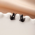 Detalle de pendientes de gato negro con diseño de corazón hueco en bandeja de cerámica - Gato Estirándose Diseño de Corazón Hueco (791 Negro)