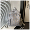 Dettaglio dello zaino in nylon grigio con motivo floreale rosa e tasca anteriore - Blu