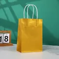 Golden metallic gift bag with white rope handles and high-gloss paper finish - Gold
