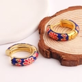 Detail of blue enamel hoop earrings with colorful flower patterns on a wood background - Royal Blue