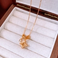 Detail van gouden klavertje vier hanger met zirkonia inlays in een vintage juwelendoosje - Ketting - Goud