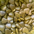 Close-up of polished olive green natural heart-shaped stones in a dense pile - Peridot