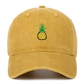 Close-up of yellow washed cotton baseball cap featuring small pineapple embroidery detail - Yellow