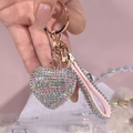 Makro-Detail des bunten Herz-Schlüsselanhängers mit rosa Lederband und Glitzersteinen - Macaron-Farbe