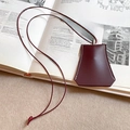 Close-up of burgundy leather bell key charm with white stitching on design magazine - 37# Wine Red Bell Key Bag