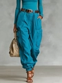 Detail of high-waist cargo pants with deep brown leather belt and chic leather handbag - Teal