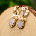 French vintage baroque pearl earrings with gold accents on a natural wood base - Pleated Petal Flat Pearl Earrings