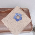 Gros plan d'une barrette à cheveux fleur bleue ajourée sur un fond de lin rustique - Bleu foncé