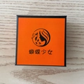 Caja de joyería naranja cuadrada con borde negro y logotipo sobre fondo de madera - Caja de Joyas Cuadrada Naranja