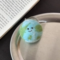 Handmade wool felt earth keychain in blue and green with a smiling face detail - Earth Globe