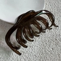 Close-up of the smooth jelly-like dark brown hair claw clip with multiple teeth structure - Tea Grey