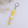 Detail of yellow flower silicone bead keychain with decorative tassel and silver clasp - Yellow