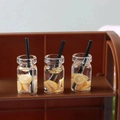 Detailed macro view of three miniature lemon soda bottles with straws on a shelf - Fruit Cup 13