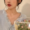 Collana chic con fiocco dorato e perle bianche indossata da una modella per donne - Oro - Perla Con Nappina e Fiocco