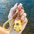 Porte-clés Capybara jaune mignon avec figurine en colle souple et lanière tressée marron. - Capybara en Résine-Style Classique