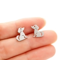 Cute puppy stainless steel stud earrings shown on finger for size reference - Sitting Dog (682) / Steel