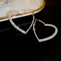 Exaggerated gold heart hoop earrings with sparkling full rhinestone inlay on black background - Full Rhinestone Gold Heart