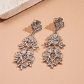 Détails macro de boucles d'oreilles fleuries argentées avec motifs métalliques ajourés - Argent (Tige en argent sterling 925)