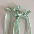 Nahaufnahme der mintgrünen Satin-Bogen-Haarspangen mit langen Bändern im Ballett-Stil - Grün